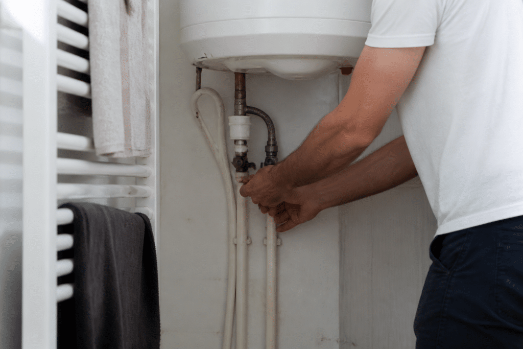Mains fermant robinet sous chauffe-eau avec serviettes