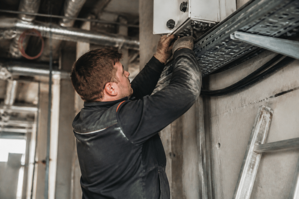 Technicien installant equipement sur chantier avec outils