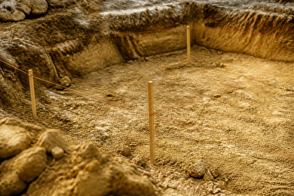 Piquets et cordeau marquant fondations sur terrain excavé