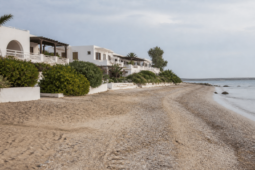 Villas côtières blanches face à plage calme et vide