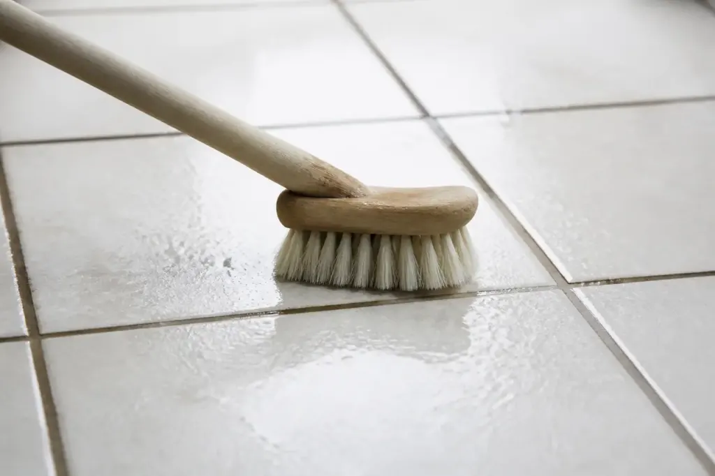 Brosse douce frottant un carrelage blanc humidifie