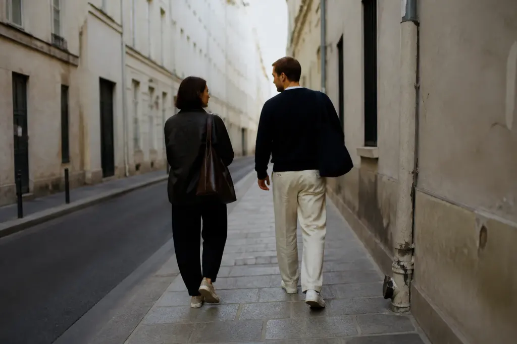 Deux personnes marchent dans une rue calme avec immeubles