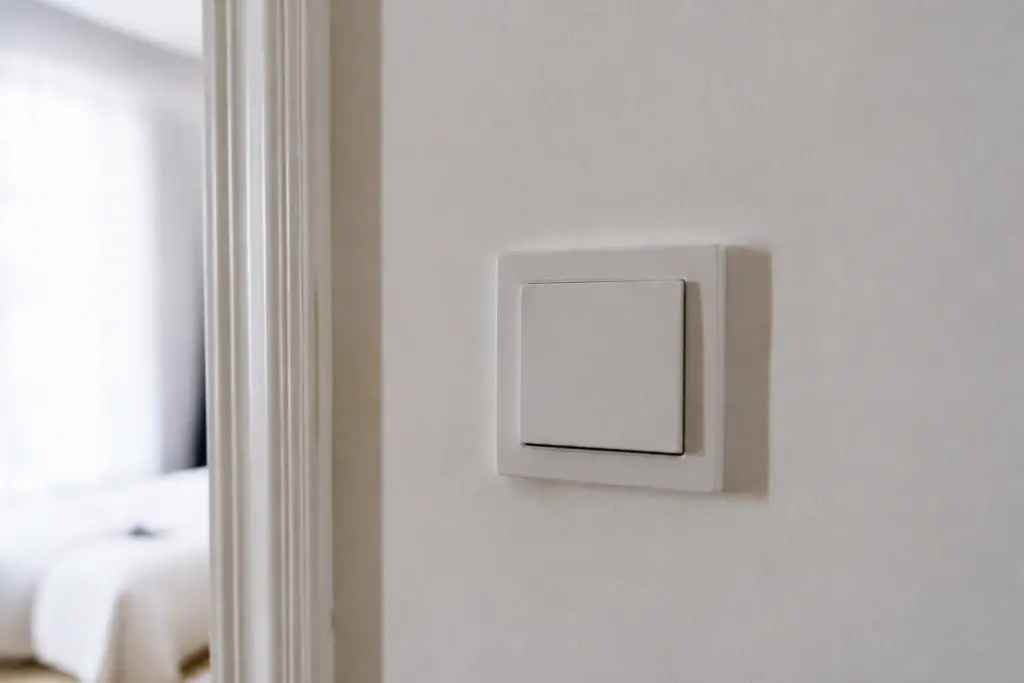 Interrupteur VMC blanc fixe sur mur de couloir