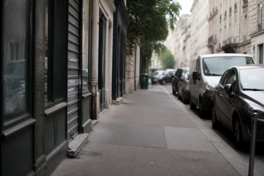 Rue avec devantures commerciales, trottoir et voitures