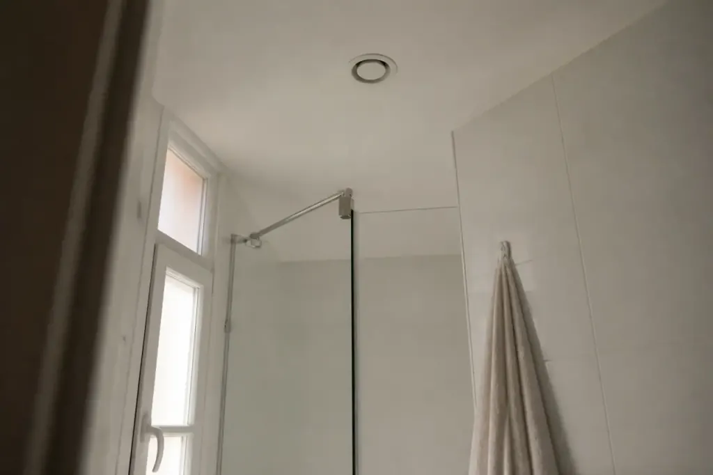 Salle de bain blanche avec bouche ronde au plafond