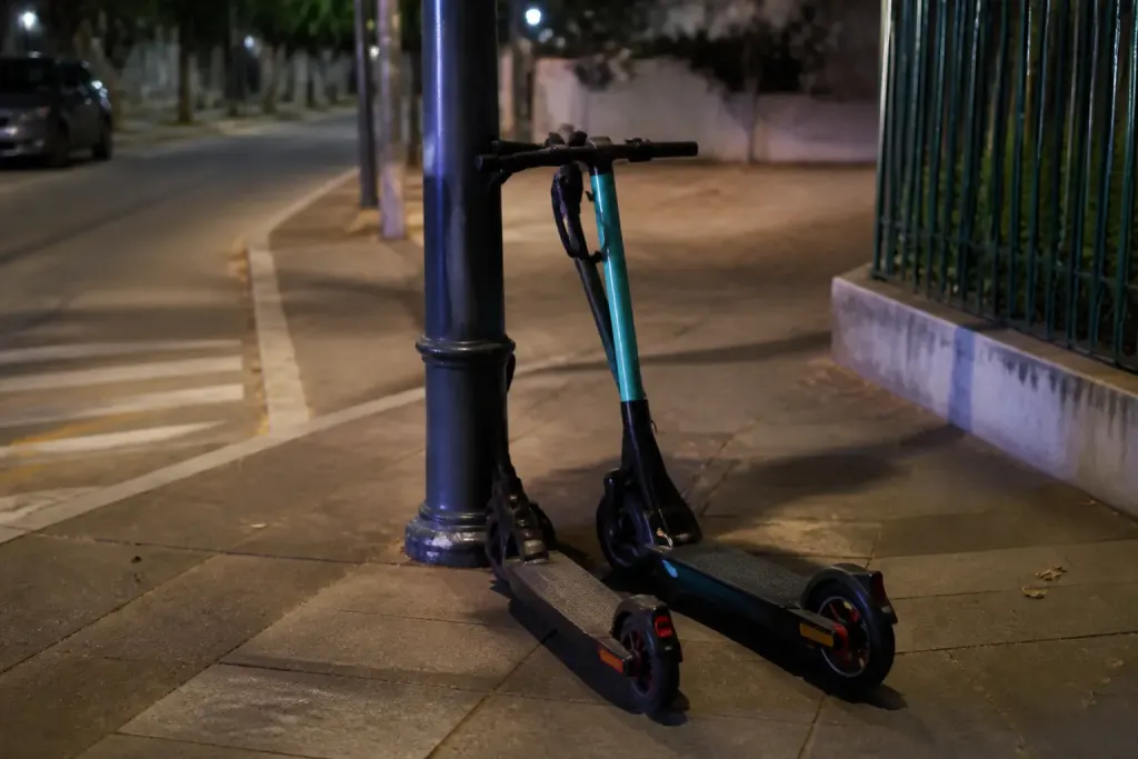 Scooters mal stationnes contre un lampadaire le soir